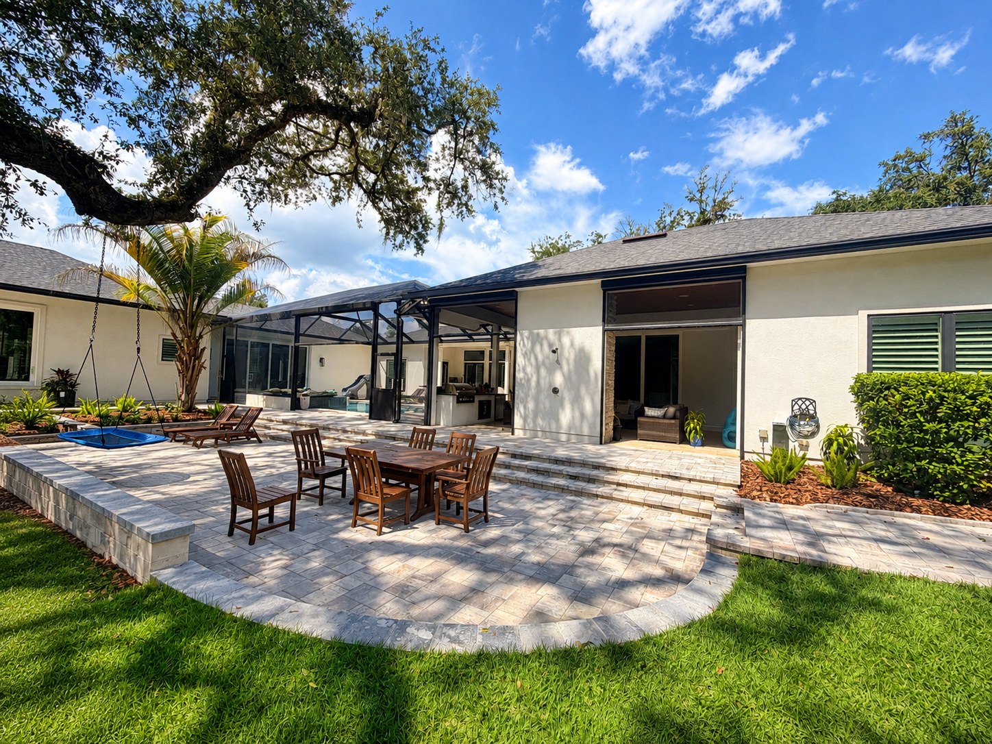 Screened pool cage with motorized screens over a paver patio and pool